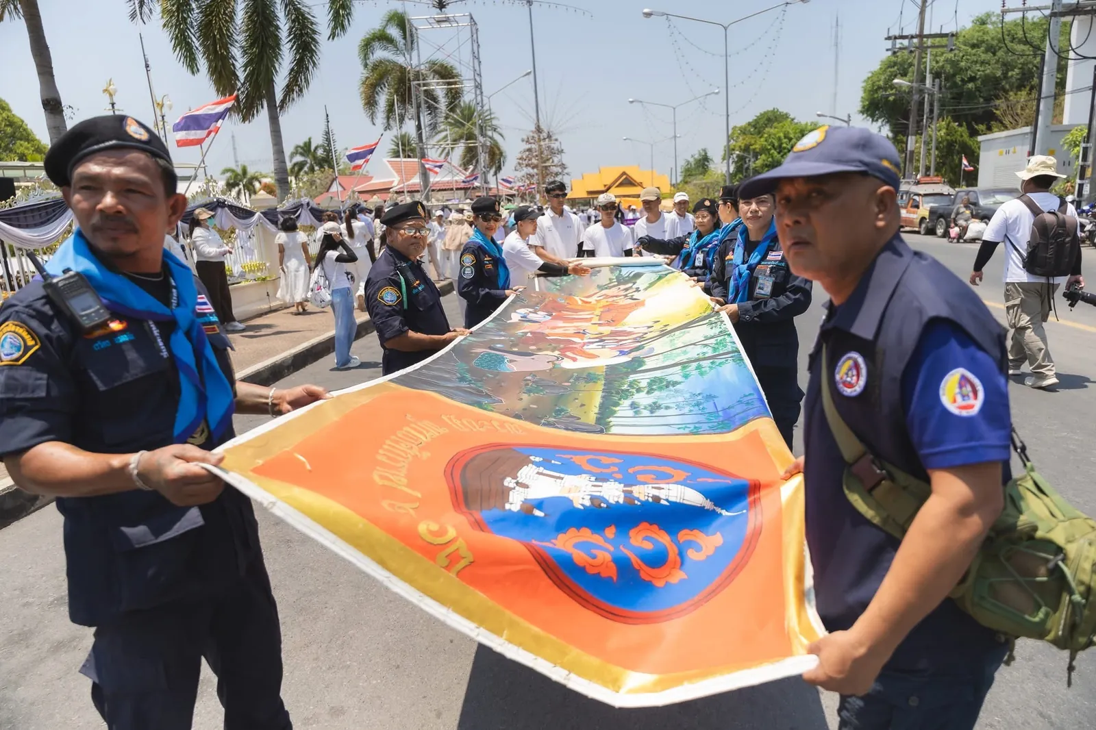 เจ้าหน้าที่ร่วมส่งต่อผืนผ้าภายในขบวนพิธี