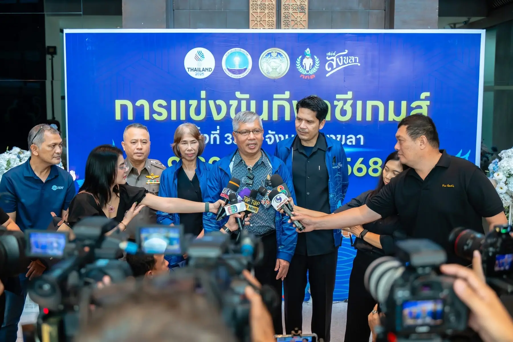 สื่อมวลชนสัมภาษณ์ผู้แทนหน่วยงานหน้าป้ายการแข่งขันกีฬาซีเกมส์