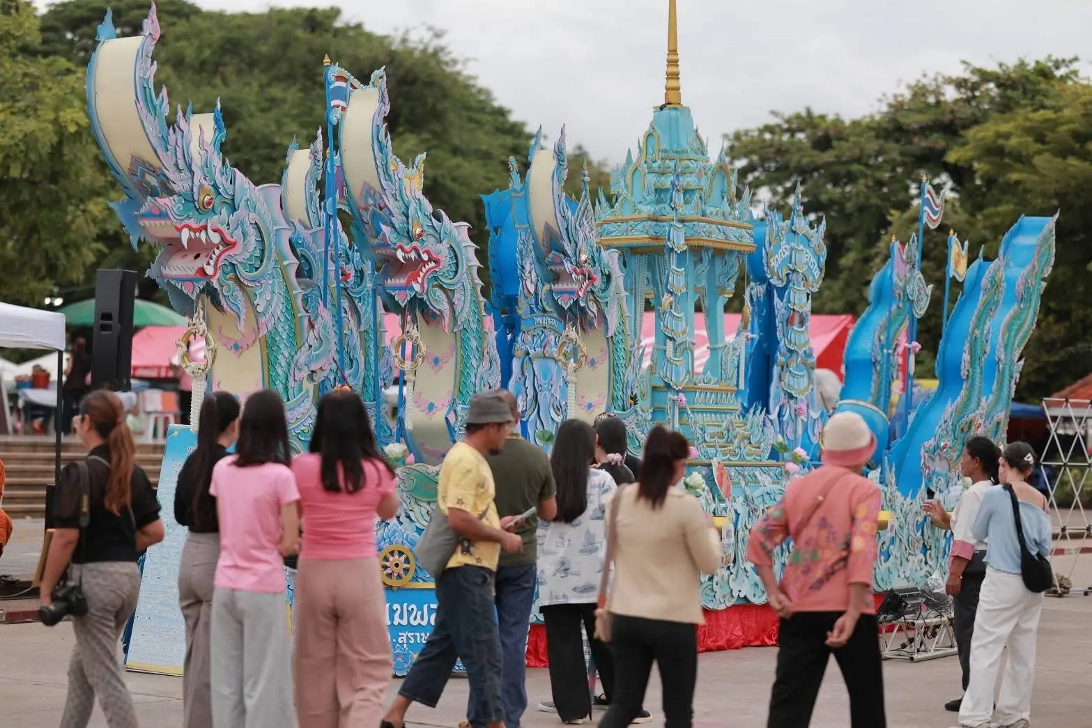 ผู้ชมชมเรือเทียนขนาดใหญ่ประดับลวดลายมังกรสีฟ้า