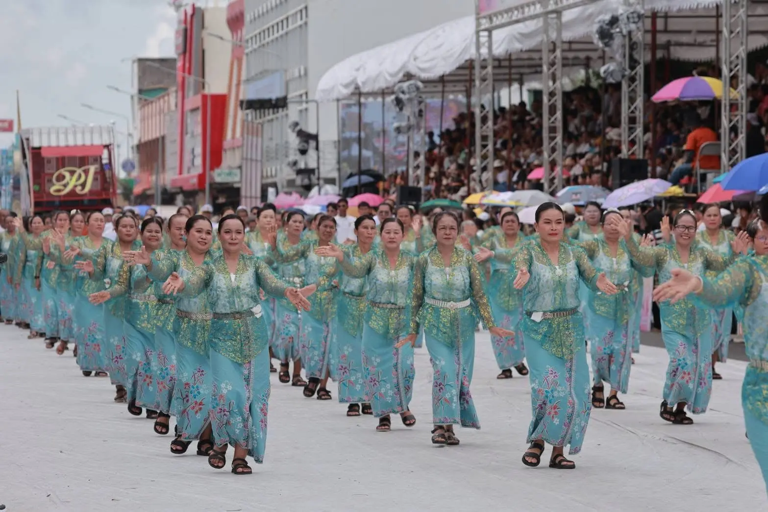 คณะนางรำในชุดสีฟ้าแสดงท่ารำในขบวนกลางวัน